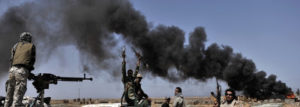 Smoke billows as Libyan rebels progress westward from the town of Bin Jawad towards Moamer Kadhafi's home town of Sirte on March 28, 2011 as NATO finally agreed to take over full command of military operations to enforce a no-fly zone in Libya from a US-led coalition. AFP PHOTO/ARIS MESSINIS (Photo credit should read ARIS MESSINIS/AFP/Getty Images)